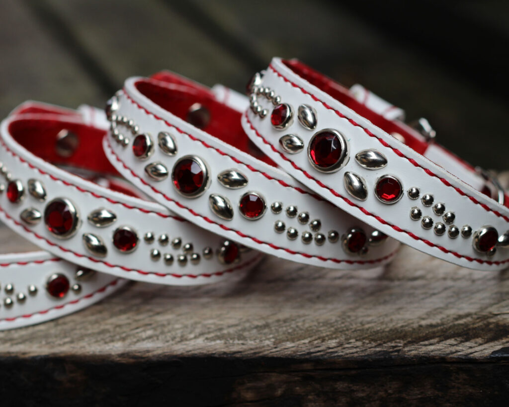 赤いアクリルスタッズとだ円型スタッズと小さな丸型スタッズでデザインされている首輪が4本　首輪の革は表が白革、裏が赤革　ミニチュアダックス4頭のオーダー品