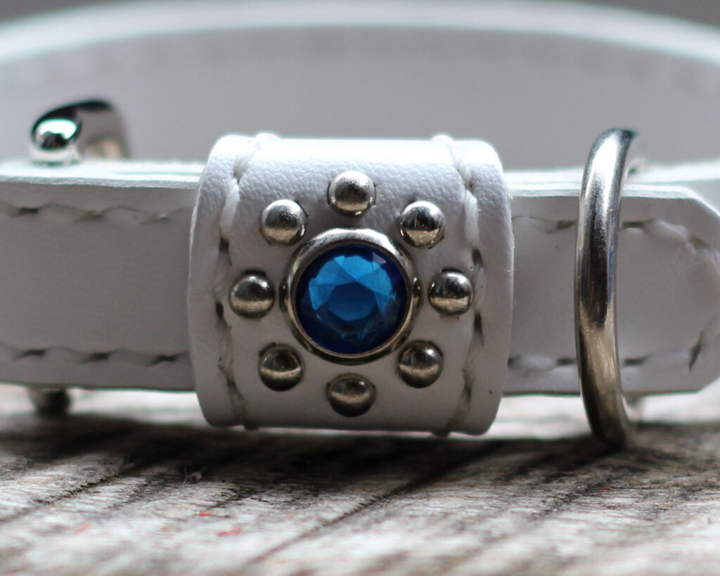 青、ライトブルー、アクアの青系のアクリルスタッズでびっしり飾られた白革のキラキラ首輪　バックル側アップ画像